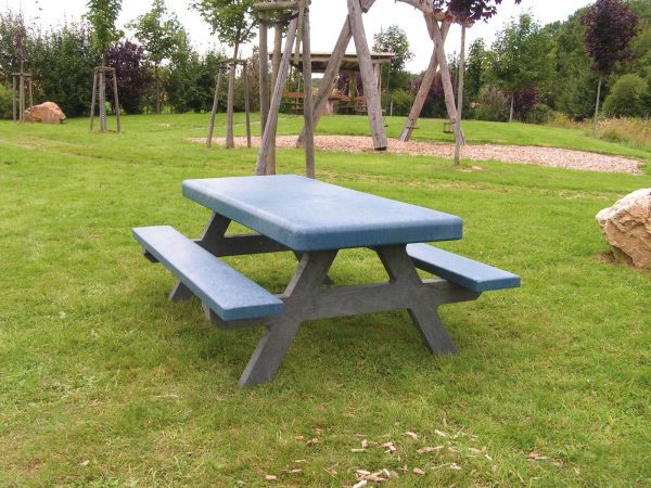 a frame kids picnic bench made from recycled plastic anchored into grass ground at play park