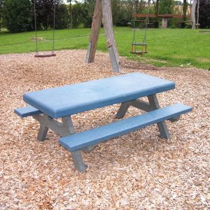 junior sized picnic table with solid top in blue on a wood shavings play park